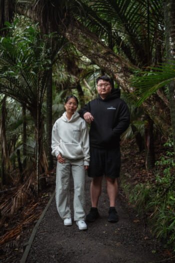 Two people on a bush track wearing Kardiá Hoodies in Snow and Night